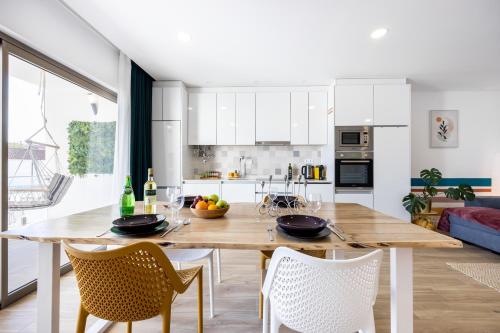 a kitchen and dining room with a wooden table and chairs at The Kuuyi Suite in Burgau
