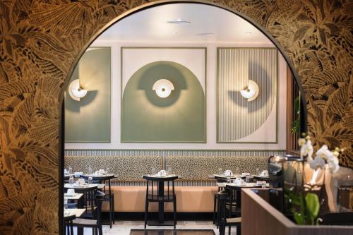 an arched doorway into a restaurant with tables at Hotel Khla Nice in Nice