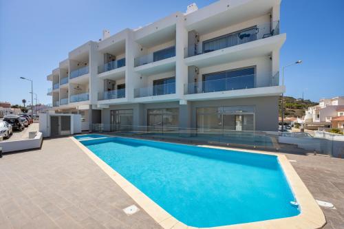 a swimming pool in front of a building at The Kuuyi Suite in Burgau