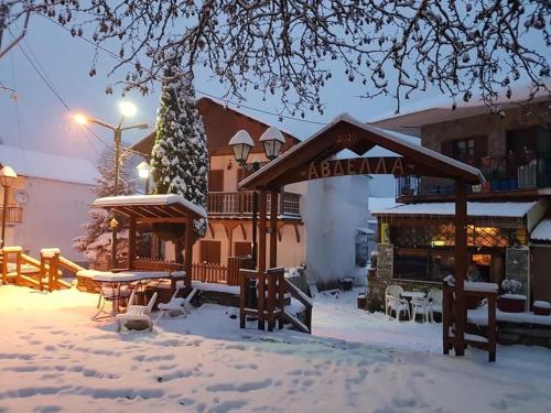 un restaurante cubierto de nieve frente a un edificio en Villa Maria Aβδέλλα, 