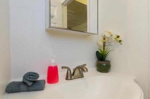 un lavandino in bagno con dispenser di sapone e specchio di Cute Studio in the Heart of Hollywood a Los Angeles