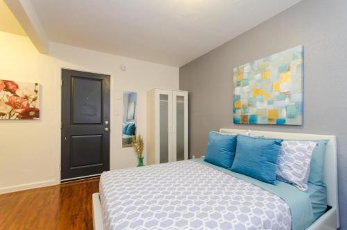 a bedroom with a bed with blue pillows at Cute Studio in the Heart of Hollywood in Los Angeles