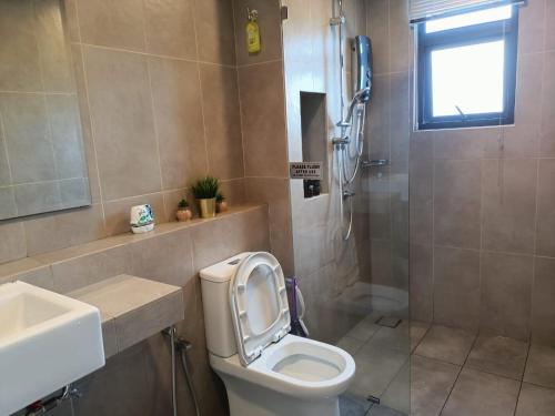 a bathroom with a toilet and a sink and a shower at Timurbay Seafront Residence By Ozzy Azizi in Kuantan