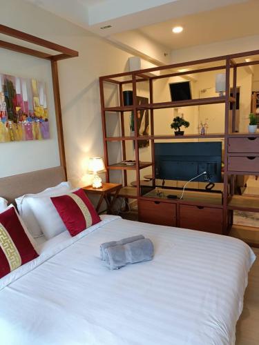 a bedroom with a large white bed and a tv at Timurbay Seafront Residence By Ozzy Azizi in Kuantan