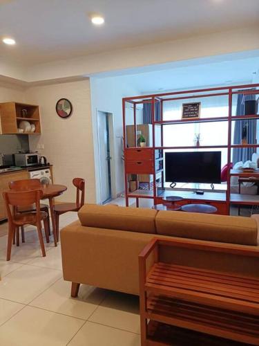 a living room with a couch and a table and a television at Timurbay Seafront Residence By Ozzy Azizi in Kuantan