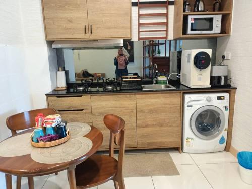 a kitchen with a table and chairs and a microwave at Timurbay Seafront Residence By Ozzy Azizi in Kuantan