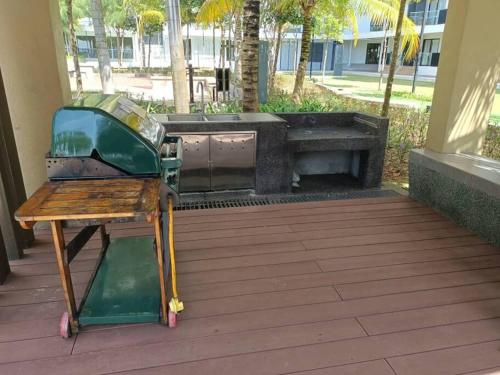 a grill and a bench on a patio at Timurbay Seafront Residence By Ozzy Azizi in Kuantan