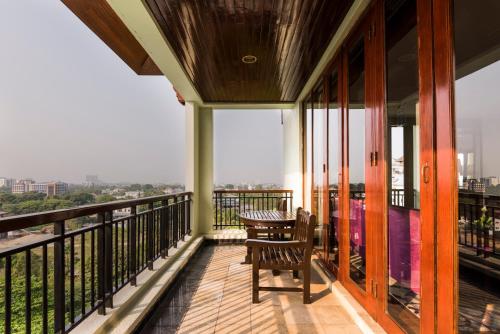 un balcón con mesa y sillas. en Hotel Chatrium Royal Lake Yangon en Yangón