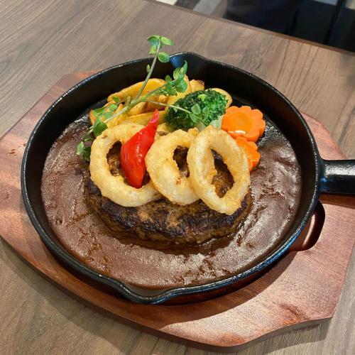 a plate with a steak with onion rings and vegetables at Urban Hotel Kyoto Gojo Premium in Kyoto