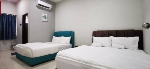 a hotel room with two beds with white sheets at Bahagia 137 Homestay with private pool in Port Dickson