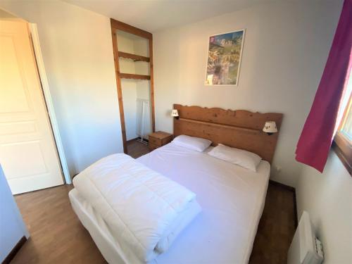 une petite chambre avec un lit blanc et une fenêtre dans l'établissement Appartement cosy 4 pers, balcon, parking gratuit, proche pistes - FR-1-504-655, à Saint-Étienne-en-Dévoluy