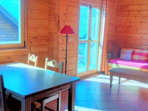 Cette chambre comprend une table, un lit et une lampe. dans l'établissement Chalet 6 pers avec piscine & parking, La Joue du Loup - FR-1-504-638, à Saint-Étienne-en-Dévoluy