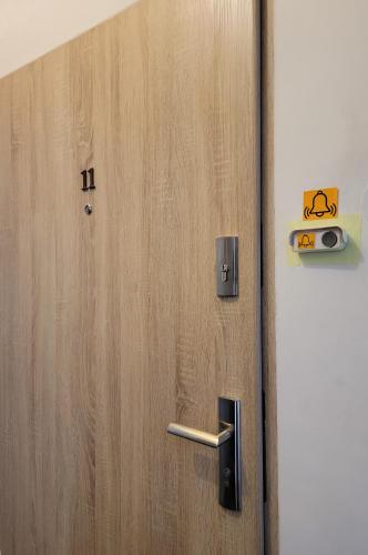 a wooden door with a handle next to a wall at Apartament Za Murami Gliwice in Gliwice