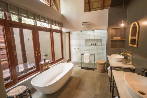 a large bathroom with a large tub and a sink at Kubu Metsi Lodge in Matlhagame