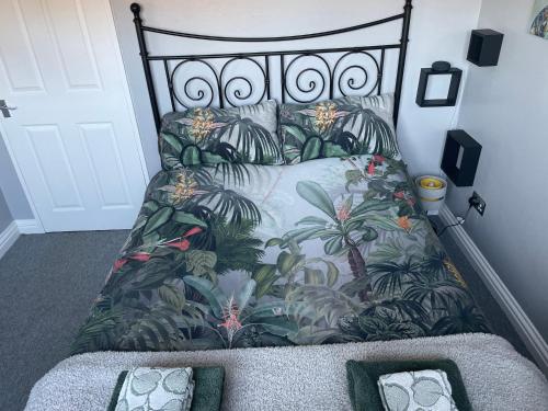 Un dormitorio con una cama con una huella tropical. en 27 The Limes Room 1 en Stockton on the forest