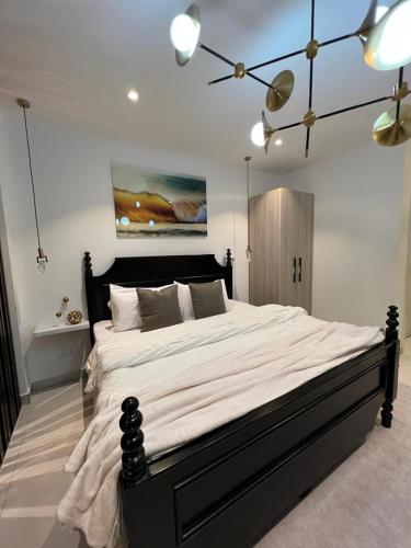 a bedroom with a large bed with a black frame at The Lennox Luxury Apartment in Accra