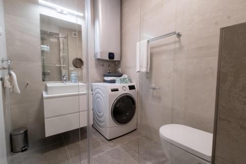 a bathroom with a washing machine and a sink at MAAN BZ15 Luxury Apartment in Zadar