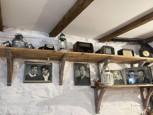 a shelf with pictures of people on a wall at Namaste къща в село Камилски дол in Kamilski Dol