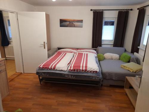 ein kleines Schlafzimmer mit einem Bett und einem Sofa in der Unterkunft Holiday Home Doris in Bad Goisern
