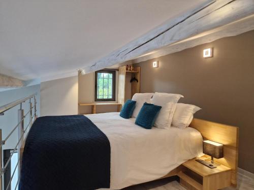 a bedroom with a large white bed with blue pillows at Luxury Zen in Châteauneuf