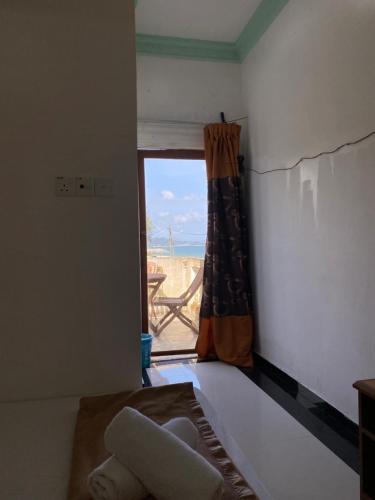 a bedroom with a window and a bed with a view at Raihan Beach Resort in Dungun