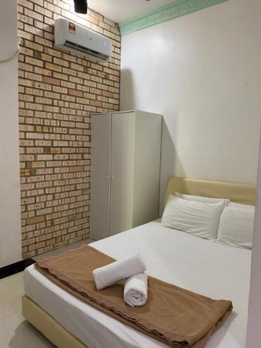 a bedroom with a bed with two towels on it at Raihan Beach Resort in Dungun