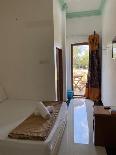 a bedroom with a bed and a door to a patio at Raihan Beach Resort in Dungun