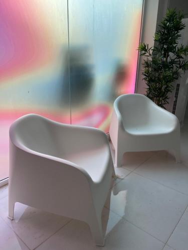 einen weißen Stuhl und einen Stuhl in einem Zimmer in der Unterkunft Hotel Oasis Park Splash in Calella
