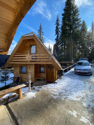 a log cabin with a car parked in front of it at Etno kuća ''Nada'' in Jahorina