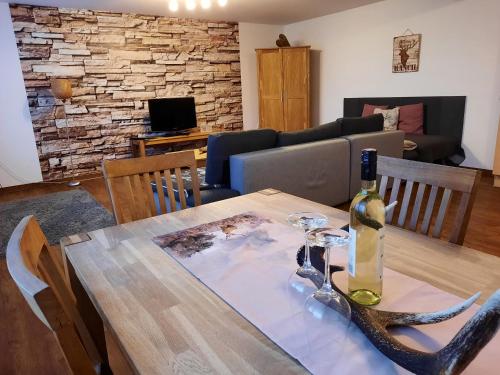 a dining room with a table with a bottle of wine at Apartment Kogler in Fügen