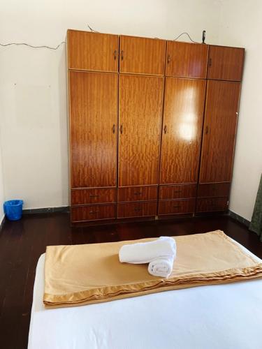 a bed with a towel on it in a room with wooden cabinets at Raihan Beach Resort in Dungun