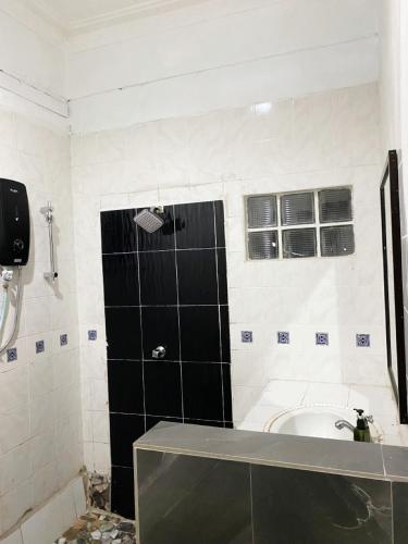 a bathroom with a shower and a bath tub at Raihan Beach Resort in Dungun