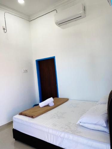 a white room with a bed with a towel on it at Raihan Beach Resort in Dungun
