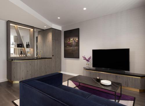a living room with a blue couch and a tv at Hotel X Brisbane Fortitude Vly, Vignette Collection by IHG in Brisbane