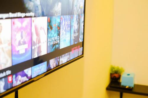 TV de pantalla plana colgada en la pared en ROOM Ijen Hostel, en Banyuwangi