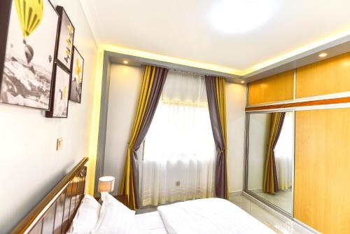 1 dormitorio con cama y ventana grande en Willington Haven, en Kampala