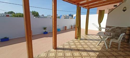 a balcony with a table and chairs on a roof at Studio pêcheur in Oualidia