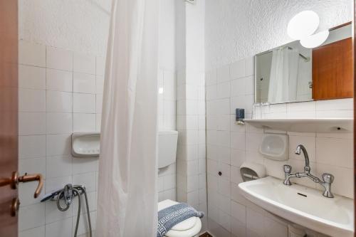 a bathroom with a sink and a toilet and a mirror at Amalia2 in Skopelos Town