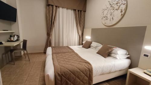 una camera d'albergo con un grande letto e una scrivania di Valmarina a Calenzano