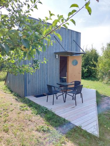 a wooden deck with a table and chairs on it at Päikesemajake 2 in Soonlepa