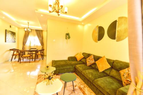 a living room with a green couch and a table at Cosy modern apartment in Naalya in Kampala