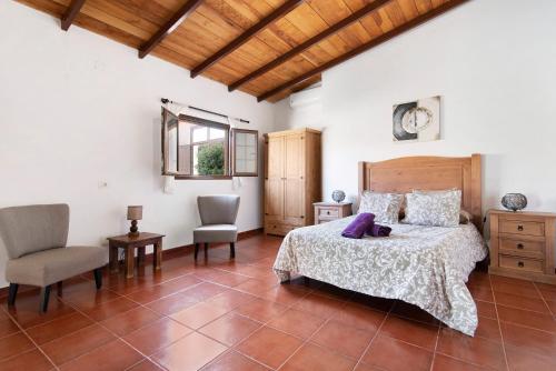 una camera con letto, sedia e tavolo di Casa Las Toscas a Ingenio