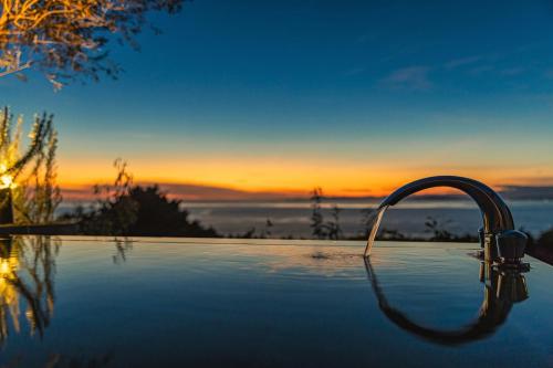 a bath tub with a faucet in front of a sunset at WEAZER 西伊豆 in Izu