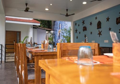 a dining room with wooden tables and chairs at The Verda De Miranda Resort Morjim North Goa in Morjim