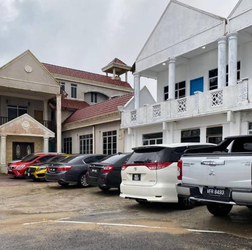 a row of cars parked in a parking lot in front of a building at Raihan Beach Resort in Dungun