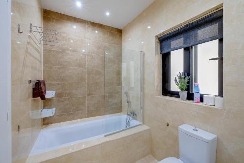 a bathroom with a shower and a tub and a toilet at Stylish 3 Bedroom Holiday Apartment in St Julians in St Julian's