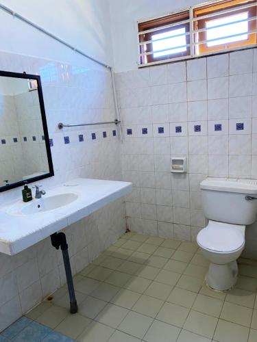 a bathroom with a toilet and a sink and a mirror at Raihan Beach Resort in Dungun