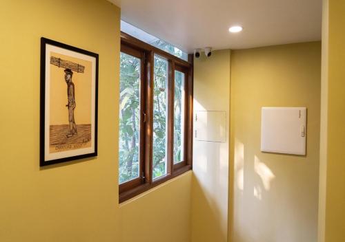 a hallway with two windows and a picture on the wall at The Verda De Miranda Resort Morjim North Goa in Morjim