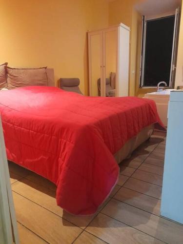 a bedroom with a red bed and a sink at Sweet BH Apt In Rome in Rome