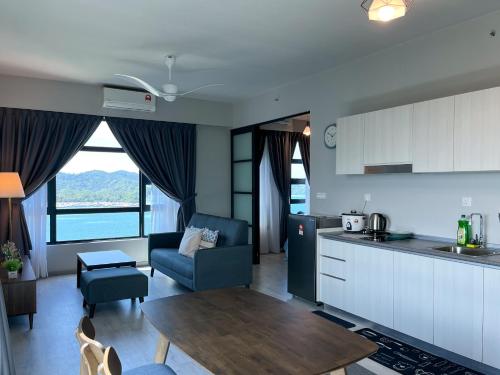 a kitchen and a living room with a table at Jesselton Point Seaview Homestay Kota Kinabalu in Kota Kinabalu